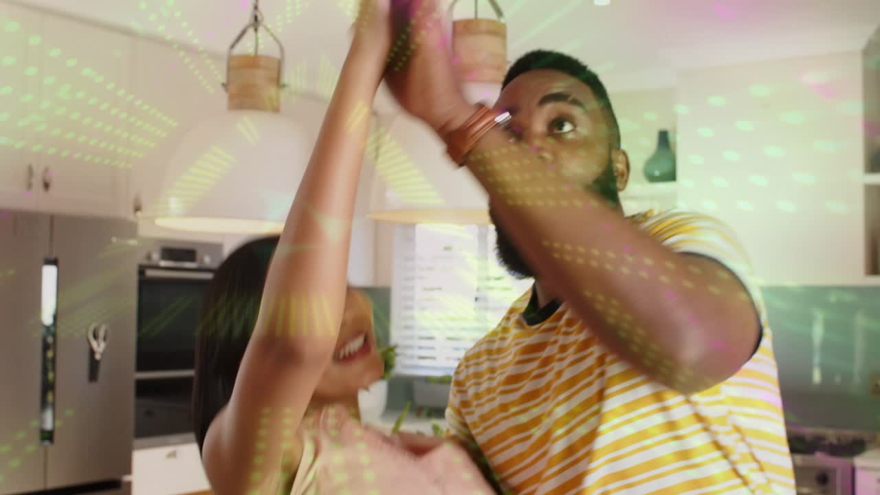 Man reaching for woman's hands leading couple into swaying turn in home celebrating with overlays