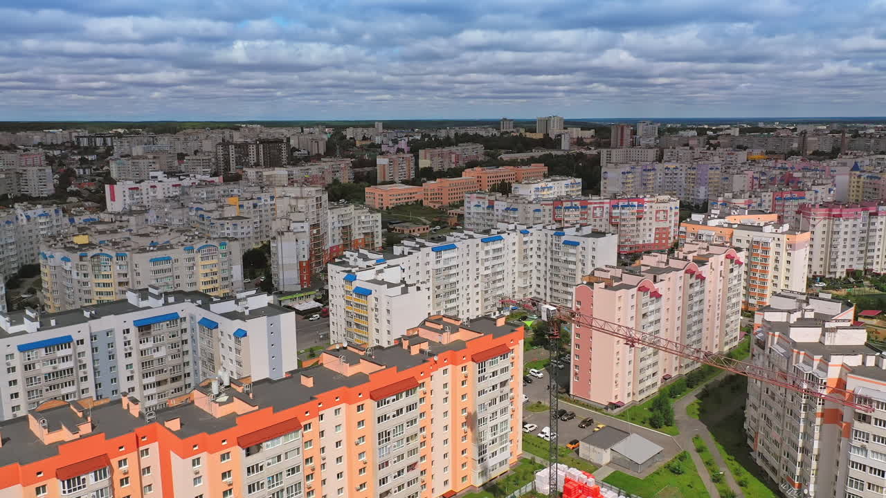 New architecture in the city. Luxury design of apartment building in a sunny day. Orange and white high-rise apartment with balconies. View from the drone
