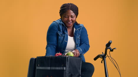 female carries out fruit basket from bag