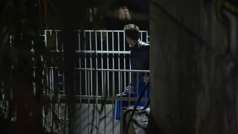 suspicious exchange of envelope and briefcase under a bridge in a park at night. dirty shady business transaction and meeting by spy agent insider. selling secrets or information for bribe money fraud