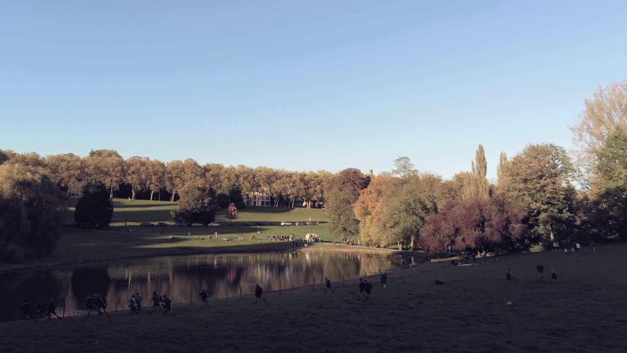 siluetas de niños felices corriendo en el hermoso parque de otoño al atardecer - toma aérea de drones