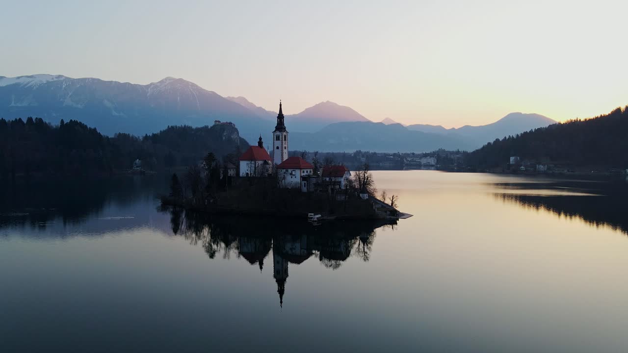 Alba mozzafiato sul Lago di Bled, che mette in risalto la chiesa sull'isola, acque calme
