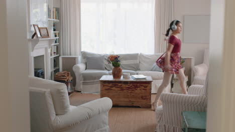 happy teenage girl dancing practicing ballet dance moves at home listening to music wearing headphones having fun enjoying weekend