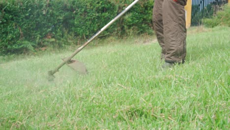 senior man mowing grass with mower