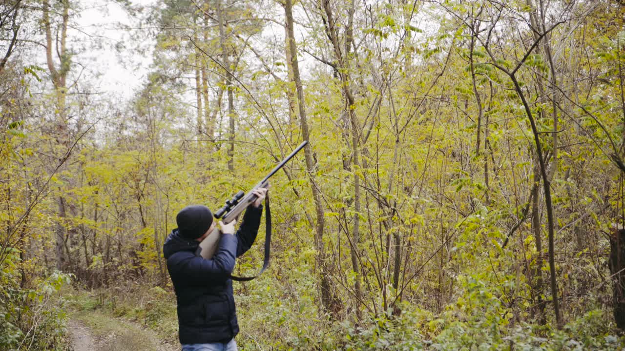 Man aiming with hunting rifle. Hunter man looking through the scope of hunting rifle