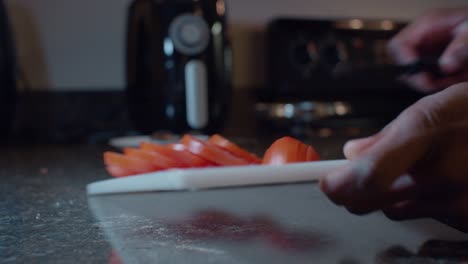 El-Hombre-Quita-El-Tomate-Rojo-Fresco-En-Rodajas-Y-La-Tabla-De-Cortar-Blanca-De-Plástico-De-La-Encimera