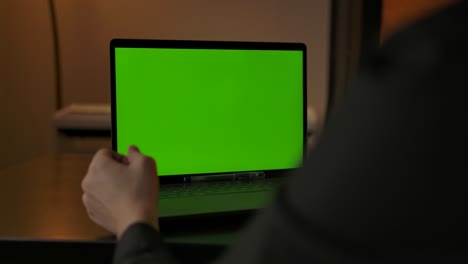 hombre irreconocible haciendo una llamada en línea a través de una cámara web portátil con pantalla chromakeyed