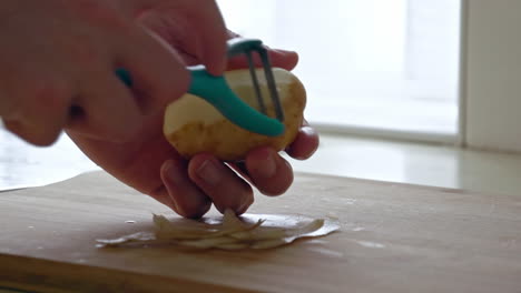 A-close-up-of-peeling-a-potato-with-a-peeler