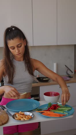 woman prepares fresh spring rolls in kitchen