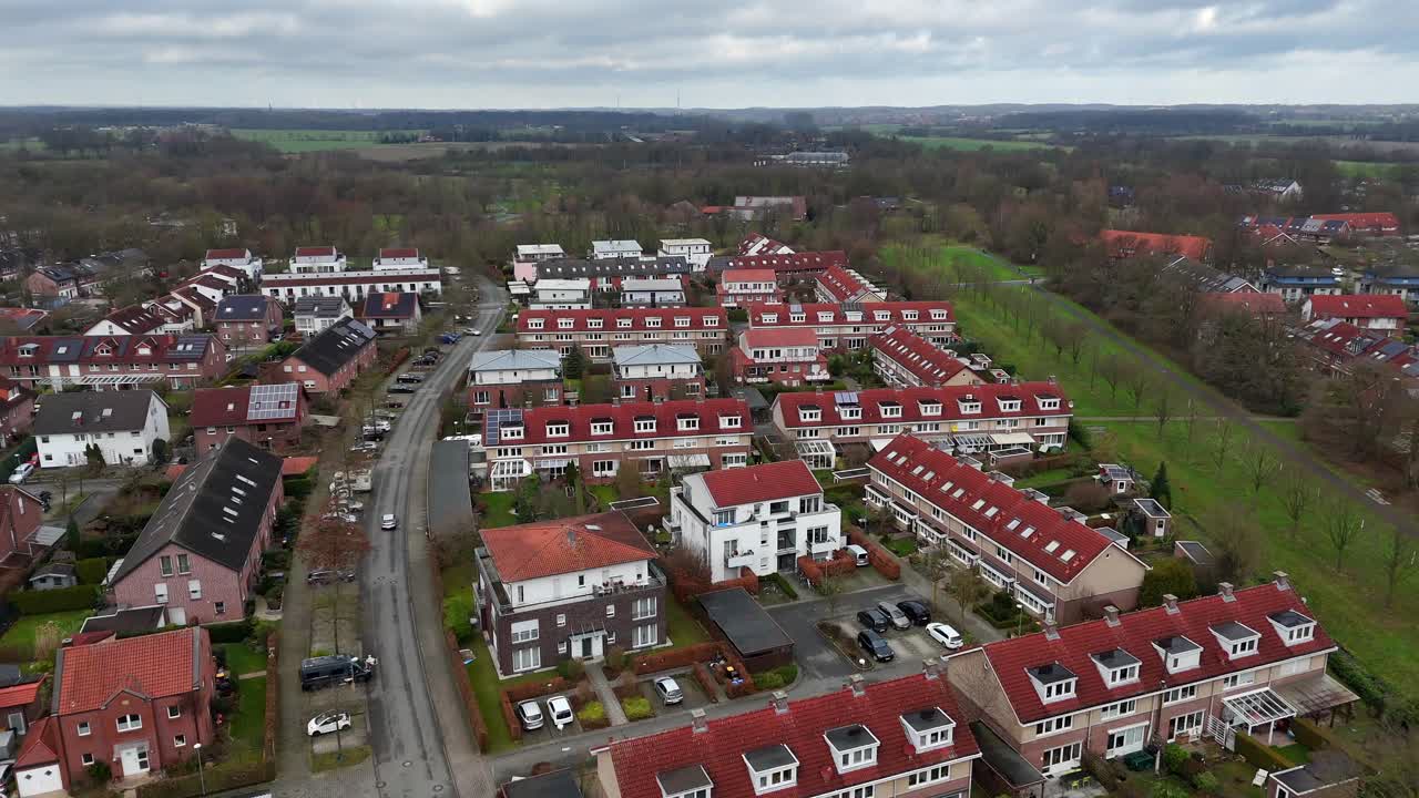 Aerial flyover residential quarter with red roof in suburb of american town. Aerial birds eye shot. Cloudy winter day. Row of homes with garden in small historic town.