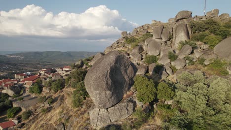 pedra enorme orbitando aérea na colina íngreme revelando vila pitoresca, monsanto