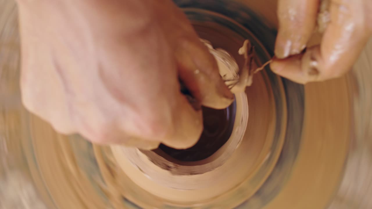 manos moldeando arcilla en una rueda de cerámica