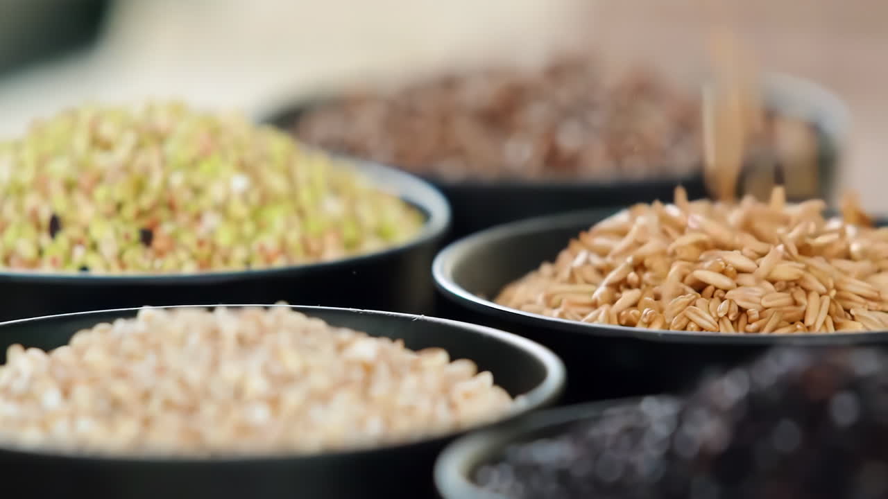 다양한 색의 다양한 원시 건강한 곡물 음식, 다양한 곡물, 곡물, 콩, 콩류는 광고 개념을 위해 목조 장식으로 회전됩니다.