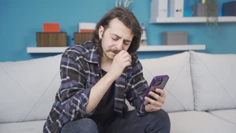 the man looking at the phone is bored and unhappy.