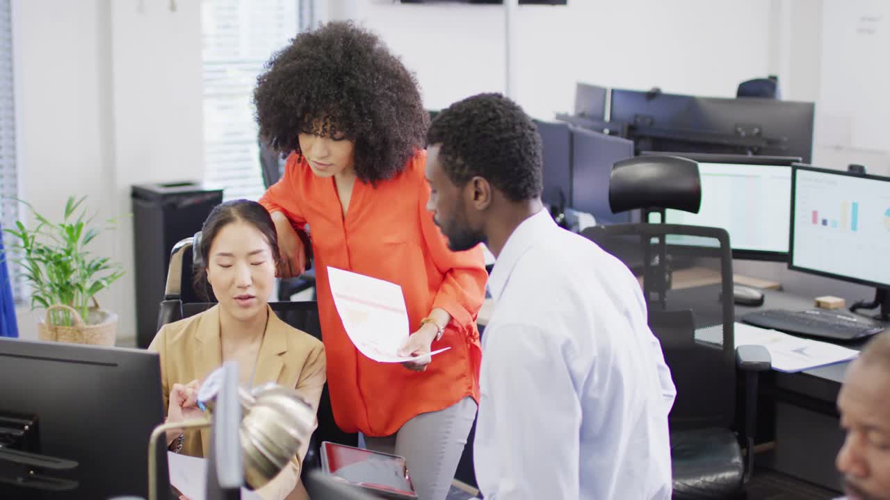 Group of diverse business people using computer and talking in office, slow motion
