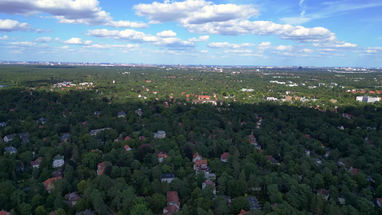 베를린의 주거 지역인 니콜라시 (nikolassee) 는 울창한 숲 속에 자리잡은 집들로 도시 지평선이 지평선에서 볼 수 있습니다.