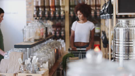 compradores que miran productos en una tienda de comestibles sostenible sin plástico