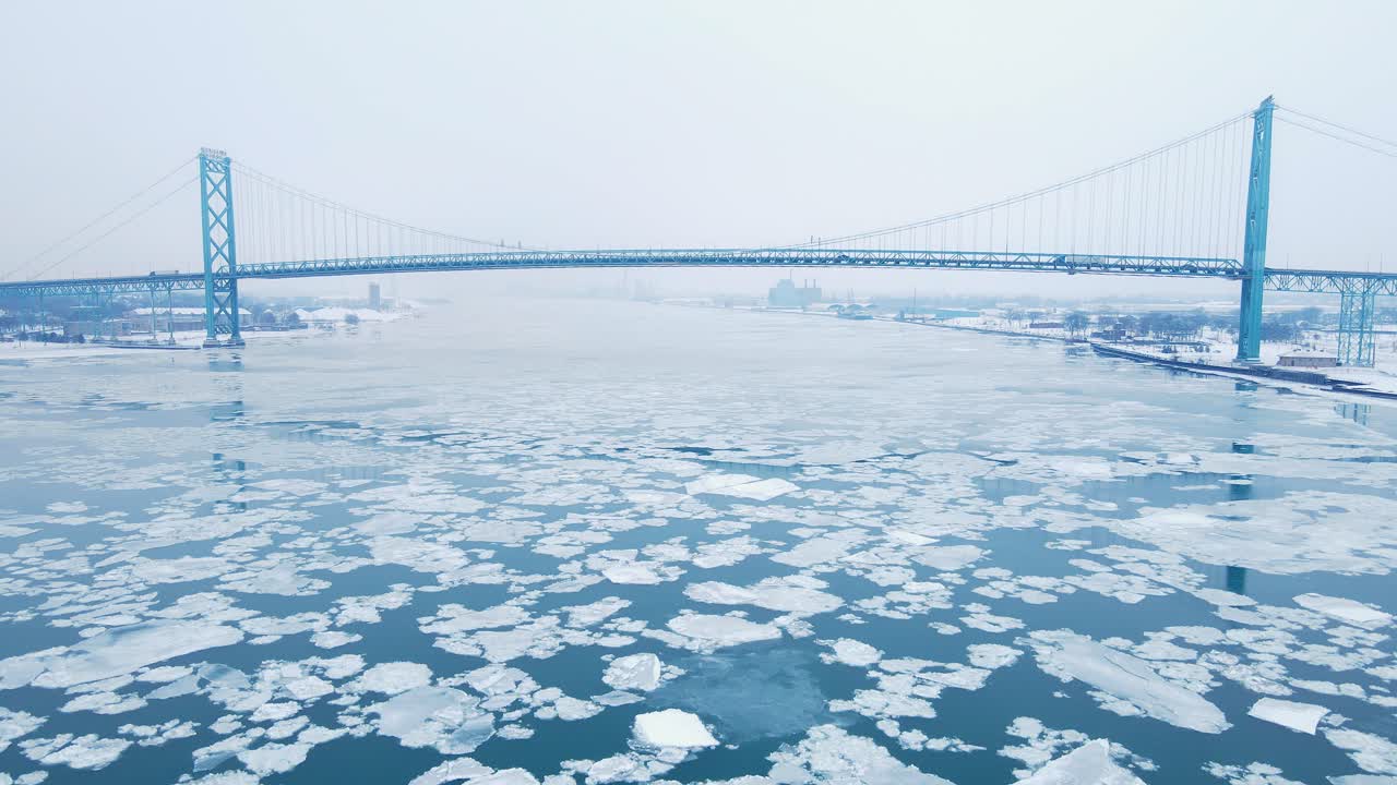 Wide view of frozen river with Ambassador Bridge and Detroit skyline