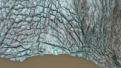 antena: volando sobre el borde de un glaciar en el agua de una laguna marrón