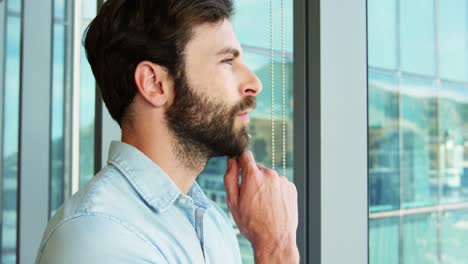 ejecutivo de negocios pensativo de pie cerca de la ventana