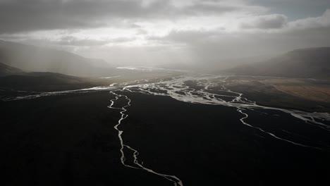 Valle-Aéreo-De-Thor,-Volando-Sobre-Un-Río-Glacial-Que-Fluye-A-Través-De-Una-Llanura-Volcánica-Negra,-Thorsmörk-Dramático-Paisaje-épico-Islandia