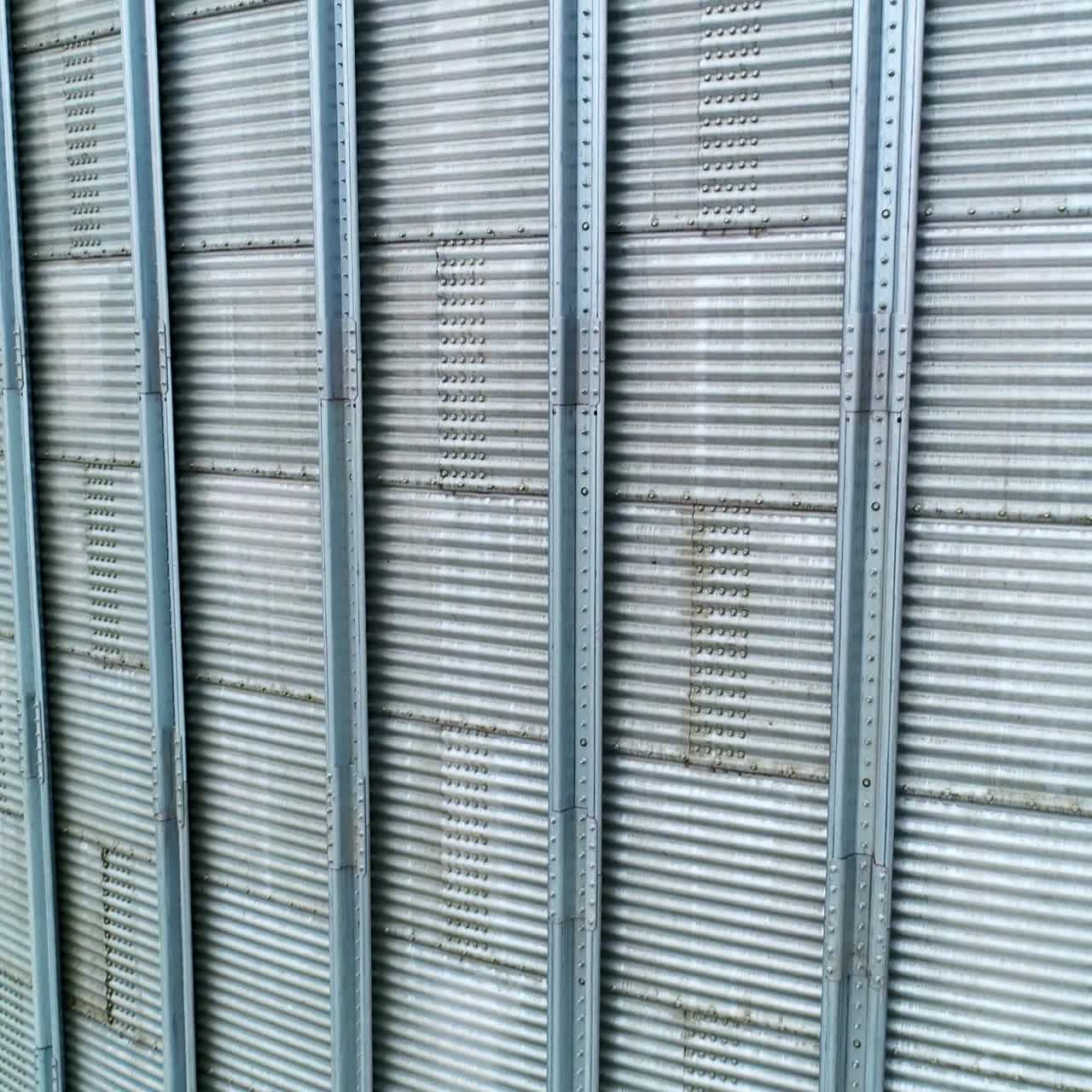 Silver metal sheathing of a modern elevator tank. Close up. Slow motion near the surface of silo cistern