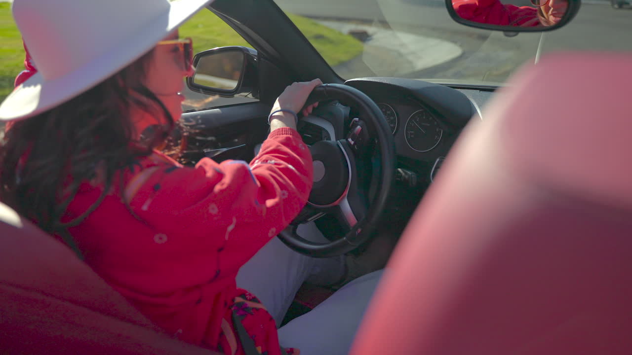 mujer conduciendo un coche descapotable
