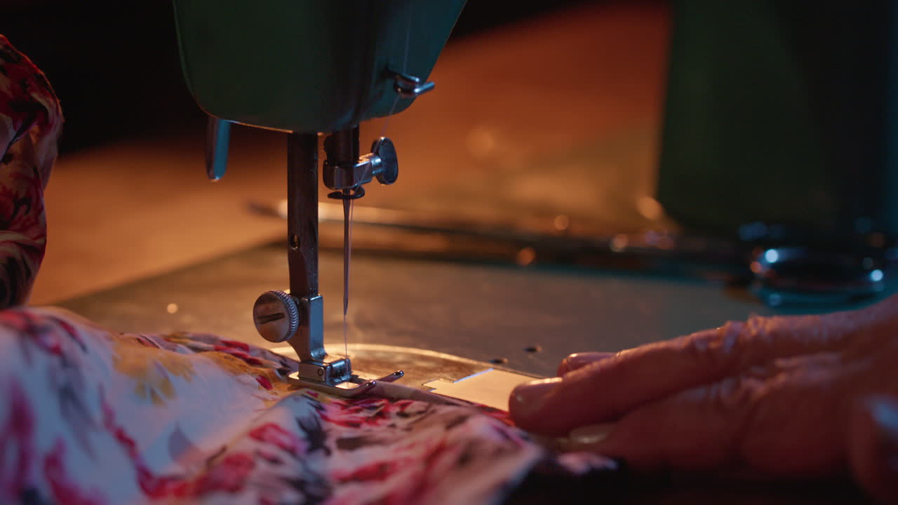 Close-up of Hands Guiding Fabric on a Sewing Machine