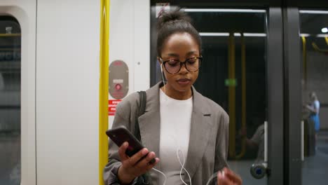 mujer usando un teléfono inteligente en un metro