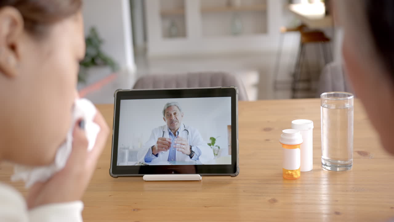 Consulting doctor online, asian woman holding tissue and watching tablet on table