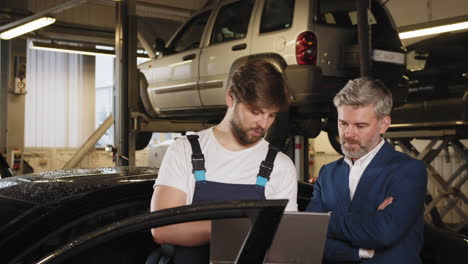 mechanic and client discussing car repair in a garage