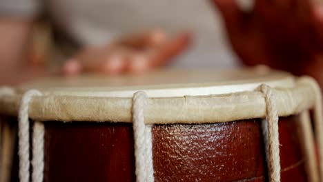 close up of hands of a man playing a drum.