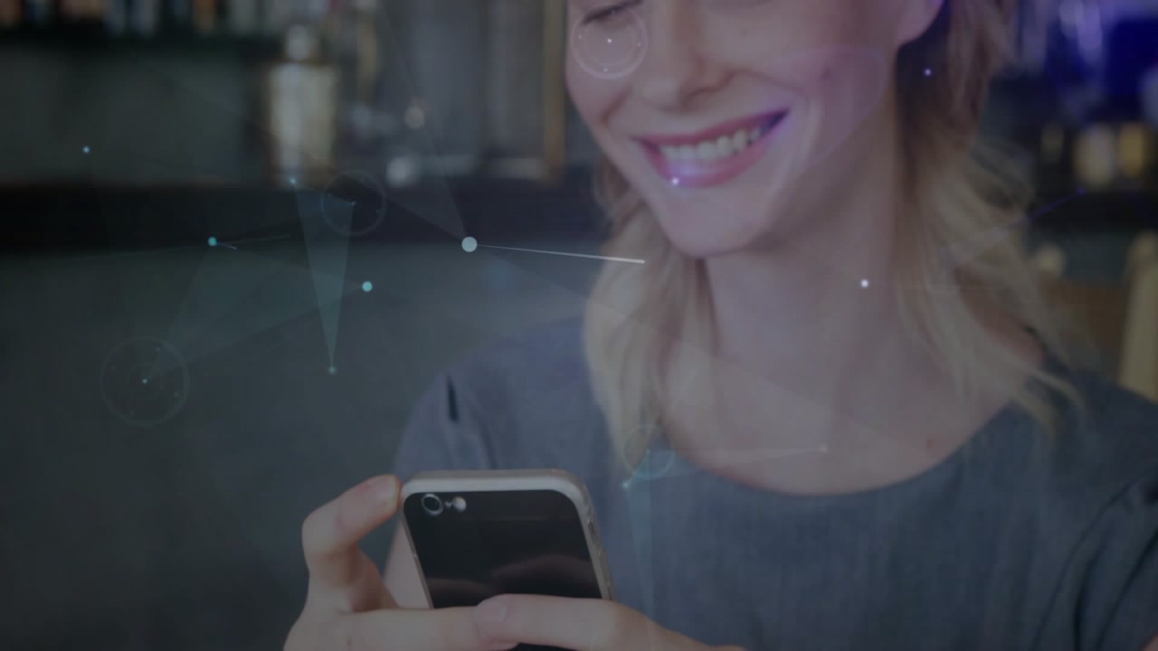 Vertical video: Tapping woman holding phone with grip in gray top, smiling reading text at bar