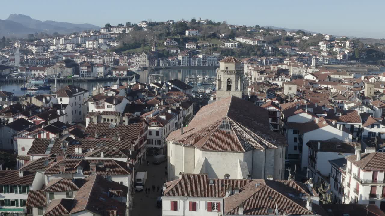 Saint-Jean-Baptiste church, bell tower, Saint-Jean-de-Luz historic centre, cityscape, France. Aerial forward