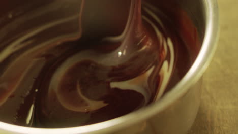 Closeup-melted-dark-and-white-chocolate-mixing-with-spatula-in-slow-motion.