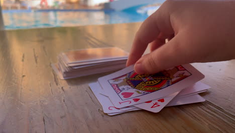 Jugando-A-Las-Cartas-Junto-A-Una-Piscina-Durante-Las-Vacaciones-Bajo-El-Sol