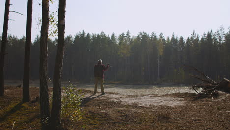 landscape-of-beautiful-nature-of-autumn-forest-with-river-and-human-enjoying-view-fisher-is-admiring