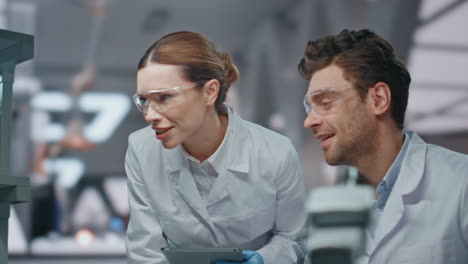 socios trabajando en el laboratorio de ciencias mirando el ordenador de cerca. investigador sonriente