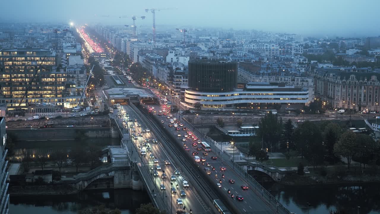 View over a foggy modern Paris and the Pont de Nuilly bridge near La Defense, Paris, France. Time-lapse
