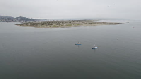 Antenne,-Die-An-Bewölkten-Tagen-über-Zwei-Paddelboarder-In-Morro-Bay,-Kalifornien,-Fliegt