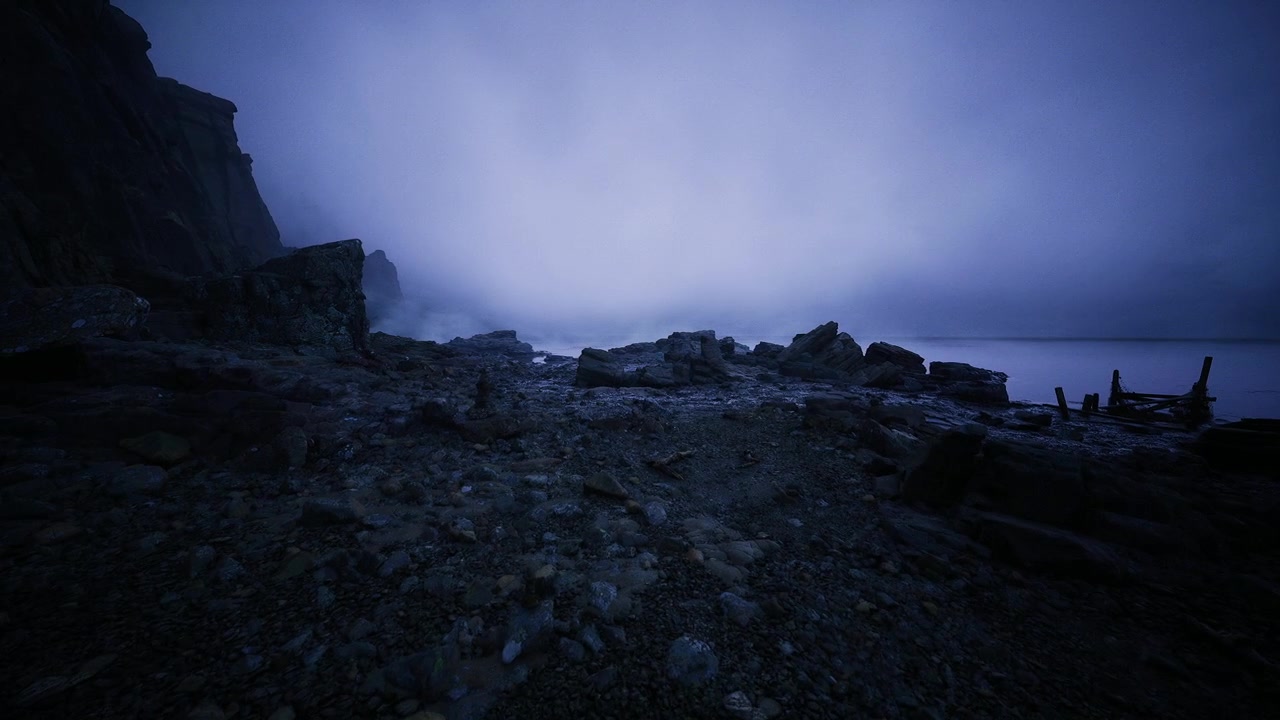 Misty coast at dusk in blue quiet seaside at sunset with fog and rocks