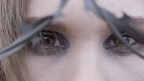 close-up of woman's face behind barbed wire