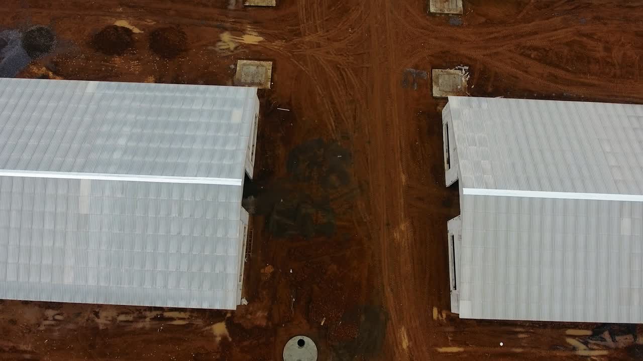 White buildings of new animal farm in the field. View from above on a new industrial complex. Flight over building area. Aerial view.