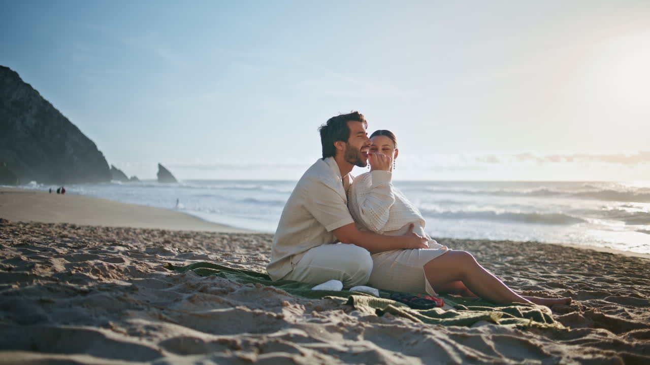 임신 중인 부모님이 해변에서 피크닉을 하고 있습니다. 임신중인 부부는 해변을 즐기고 있습니다.