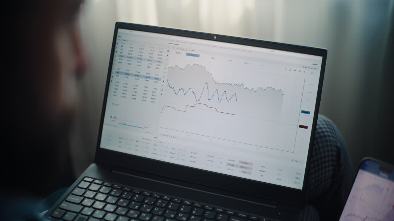 Close Up of Stock Exchange Broker Using Smartphone, Monitoring Real-Time Stocks and Exchange Market Charts in Online Trading App. Investment Agent Working in Financial Agency Office. Over the Shoulder