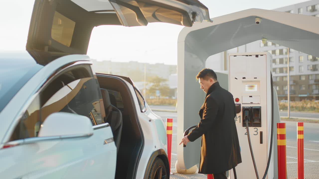 충전소 에서 전기 suv 를 충전 하는 사람