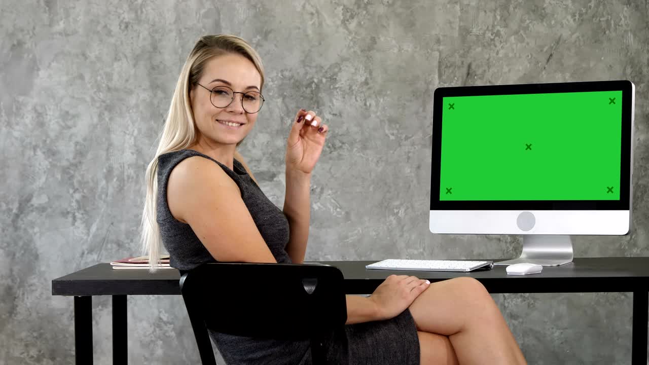Beautiful business lady in office is looking at camera and smiling. Green Screen Mock-up Display