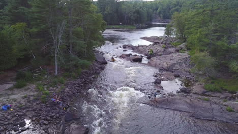 whitewater canoe goes over some rapids in a wide river