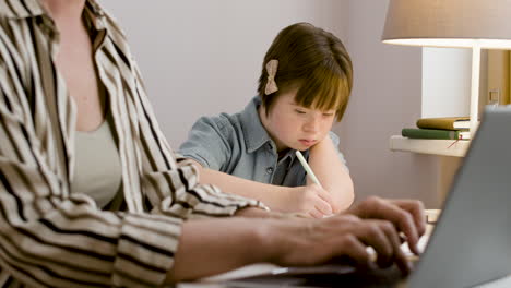 niña de diez años estudiando y mirando cómo trabaja su madre