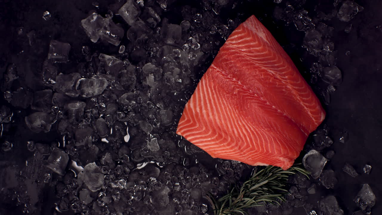 초속 스로우 모션 오버헤드 뷰: 얼음 어리에 떨어지는 신선한 지 않은 연어 필레트, 고속 카메라로 촬영, 420fps